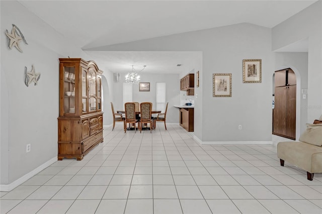 tiled dining area featuring vaulted ceiling and a chandelier