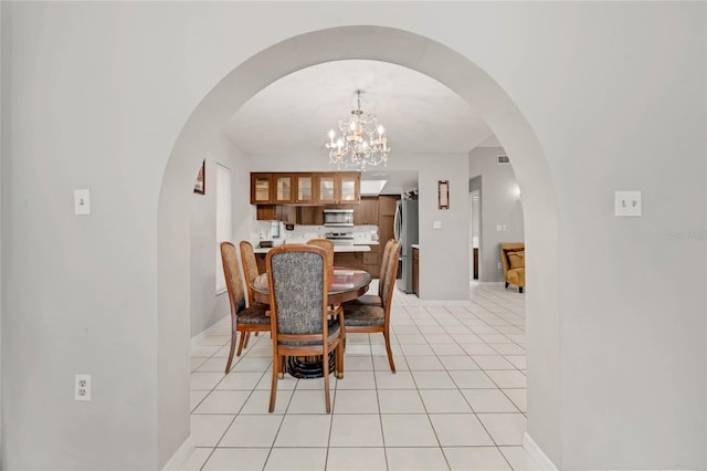 dining space with a notable chandelier and light tile patterned floors