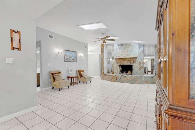 tiled living room with ceiling fan and a fireplace