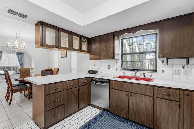 kitchen with dark brown cabinetry, sink, kitchen peninsula, dishwasher, and decorative backsplash