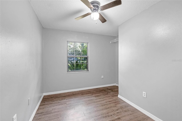 unfurnished room featuring ceiling fan, hardwood / wood-style floors, and a textured ceiling