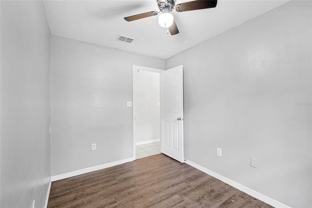 empty room featuring light wood-type flooring, a textured ceiling, and ceiling fan