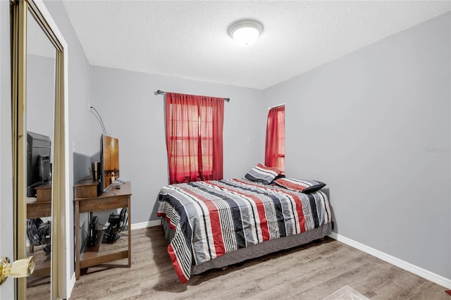 bedroom with a textured ceiling and hardwood / wood-style floors