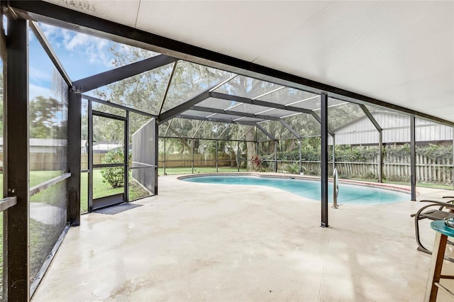 view of swimming pool with glass enclosure and a patio