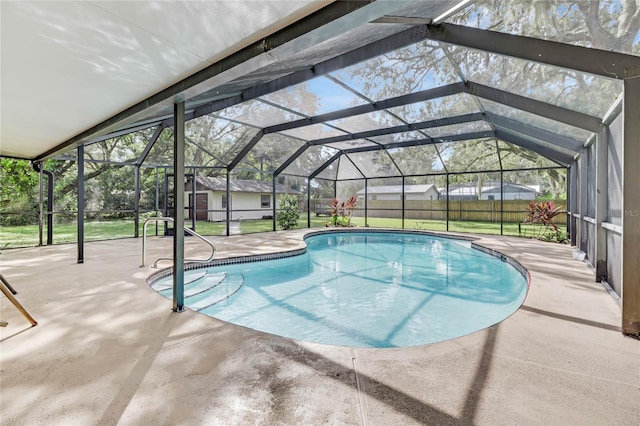 view of pool with a yard, glass enclosure, and a patio