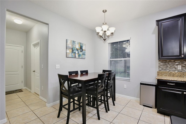 dining area featuring light tile patterned flooring and a notable chandelier