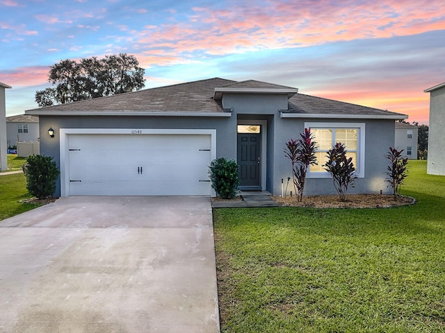 view of front of house featuring a lawn and a garage