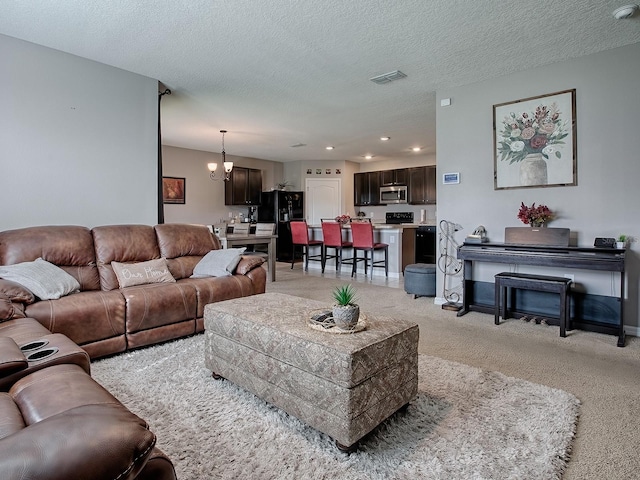 carpeted living room featuring a textured ceiling and an inviting chandelier