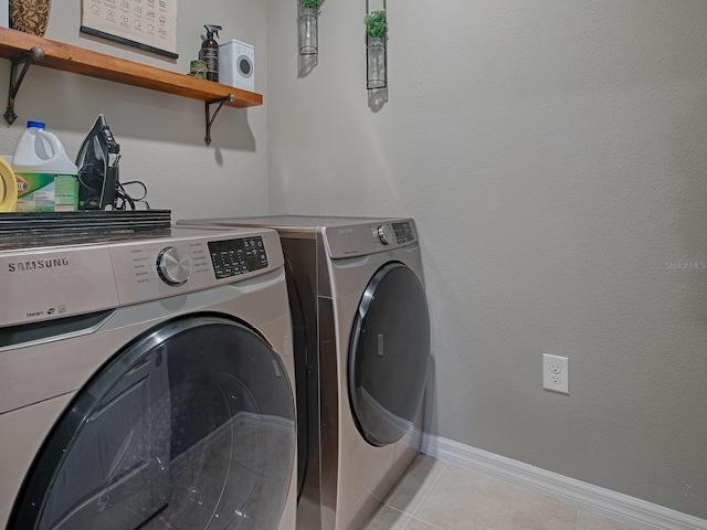 washroom featuring washer and dryer and light tile patterned floors