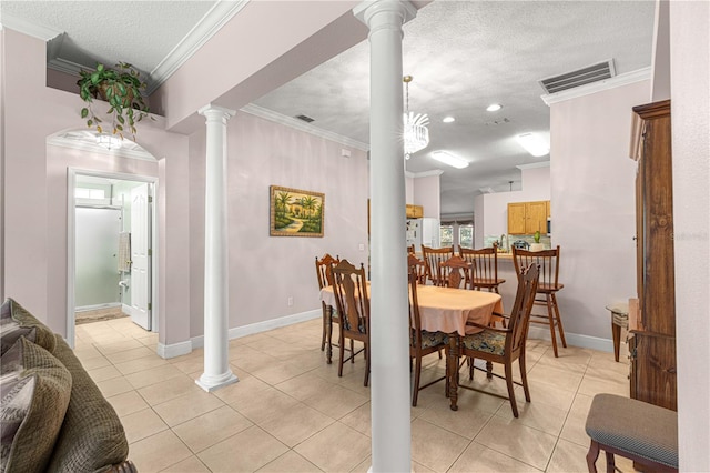 tiled dining area with ornamental molding, decorative columns, a chandelier, and a textured ceiling