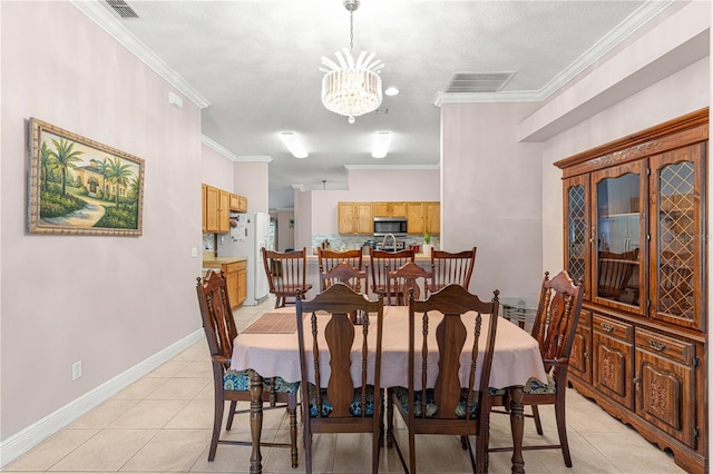 tiled dining room featuring an inviting chandelier, a textured ceiling, and crown molding