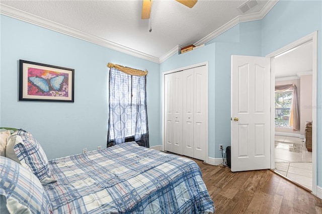 bedroom featuring ceiling fan, ornamental molding, a textured ceiling, a closet, and hardwood / wood-style floors