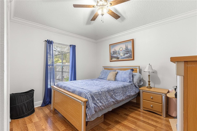 bedroom with light hardwood / wood-style flooring, a textured ceiling, ceiling fan, and crown molding