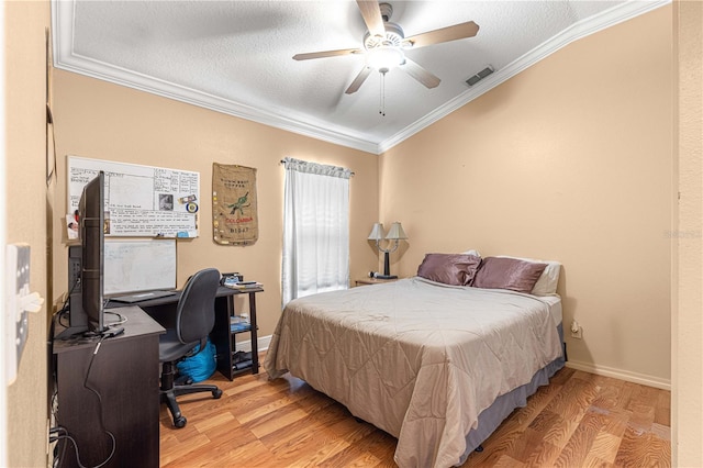 bedroom with a textured ceiling, ornamental molding, ceiling fan, and light hardwood / wood-style flooring