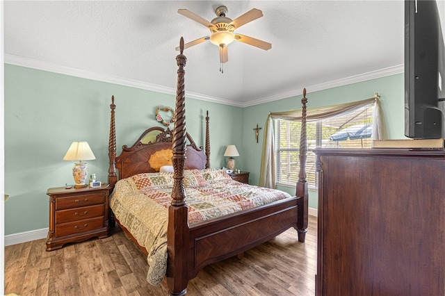 bedroom with ceiling fan, a textured ceiling, crown molding, and hardwood / wood-style floors