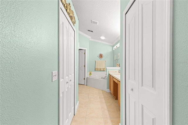 bathroom with vanity, a textured ceiling, crown molding, a tub, and tile patterned floors