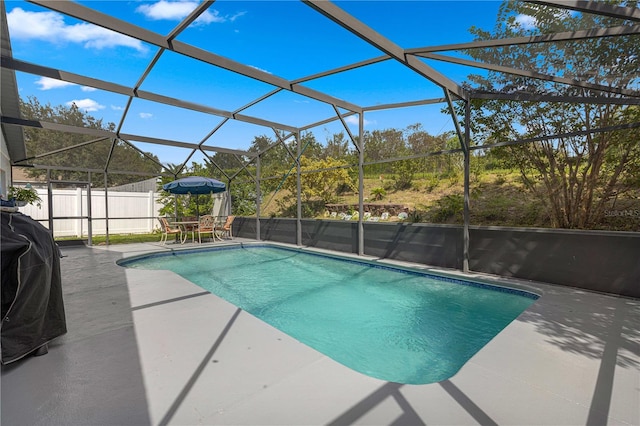 view of swimming pool featuring glass enclosure and a patio area