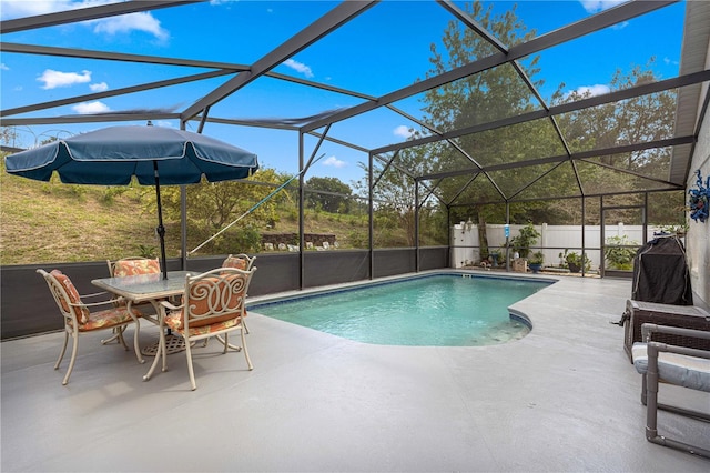 view of swimming pool with glass enclosure and a patio area