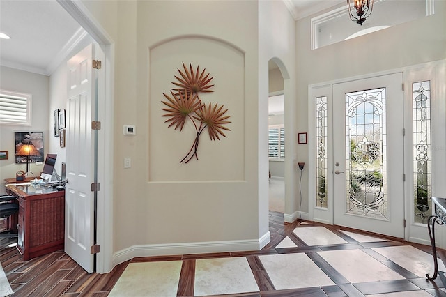 foyer with dark hardwood / wood-style flooring, a wealth of natural light, and crown molding