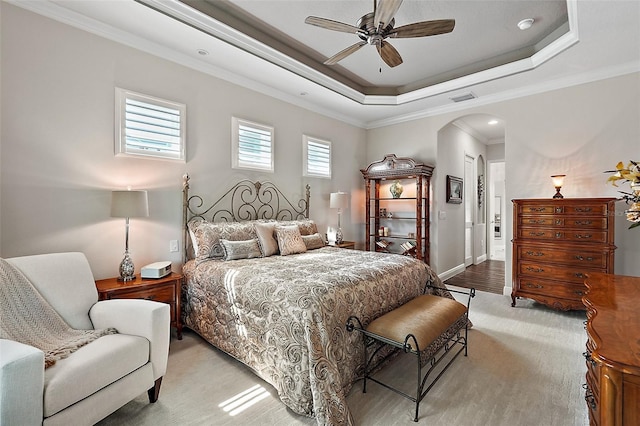 bedroom with a raised ceiling, ceiling fan, and ornamental molding