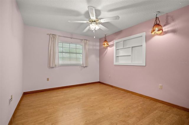 unfurnished room with light wood-type flooring, a textured ceiling, and ceiling fan