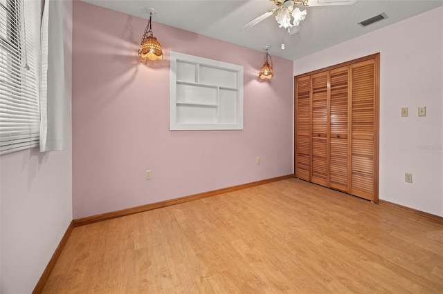 unfurnished bedroom with ceiling fan, a textured ceiling, light hardwood / wood-style flooring, and a closet