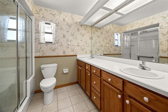 bathroom with walk in shower, vanity, tile patterned flooring, and toilet