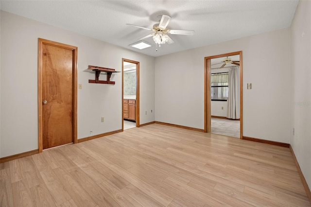 spare room with light hardwood / wood-style floors, ceiling fan, and a textured ceiling