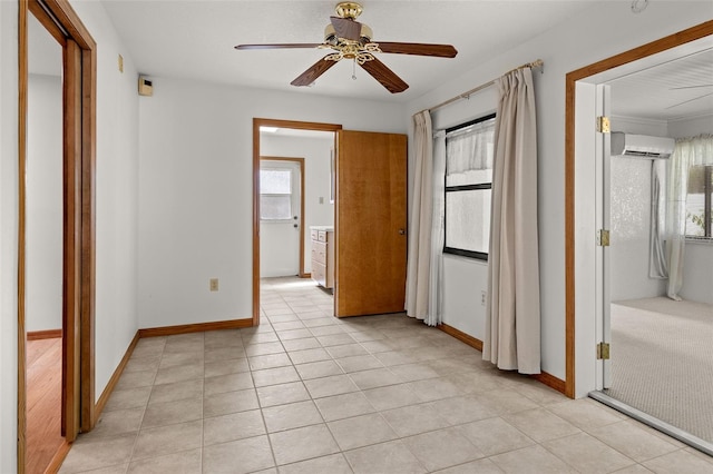 interior space featuring connected bathroom, ceiling fan, light tile patterned floors, and a wall mounted AC