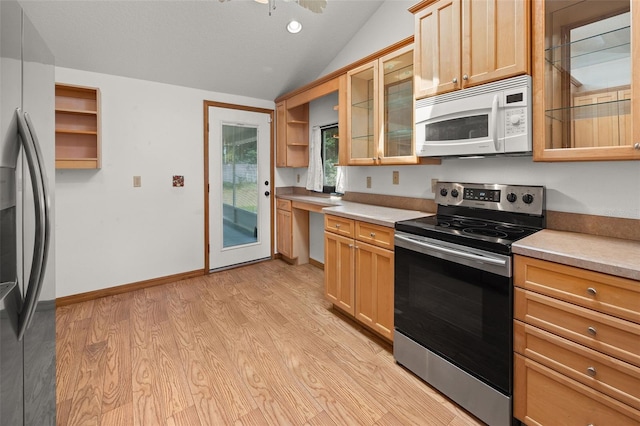 kitchen featuring light brown cabinetry, appliances with stainless steel finishes, light wood-type flooring, and lofted ceiling