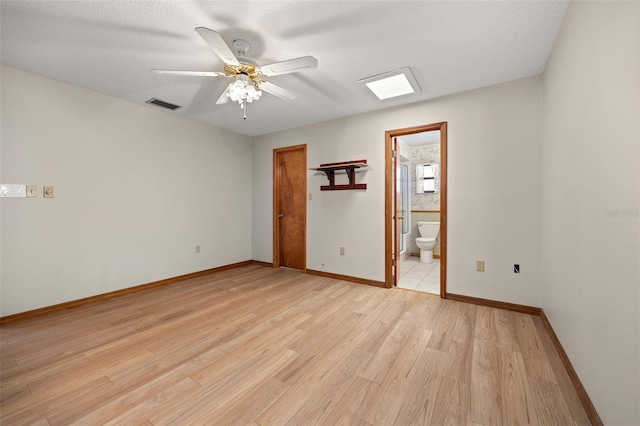 unfurnished room featuring light wood-type flooring, ceiling fan, and a textured ceiling