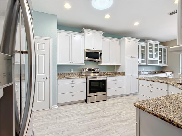 kitchen featuring white cabinetry, stainless steel appliances, and light stone counters