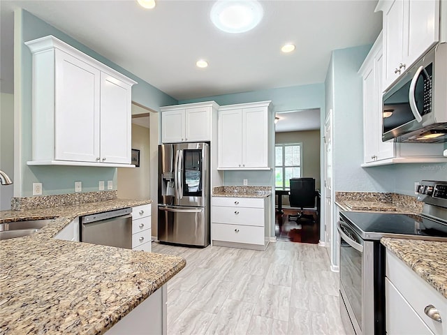 kitchen with light stone counters, sink, white cabinetry, light hardwood / wood-style flooring, and stainless steel appliances