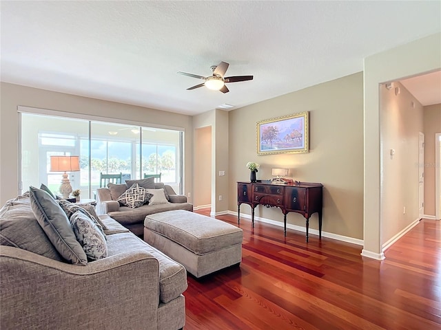 living room with ceiling fan and dark hardwood / wood-style flooring