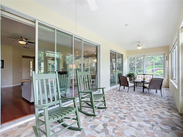 sunroom / solarium featuring ceiling fan