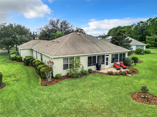 rear view of house with a lawn and a sunroom