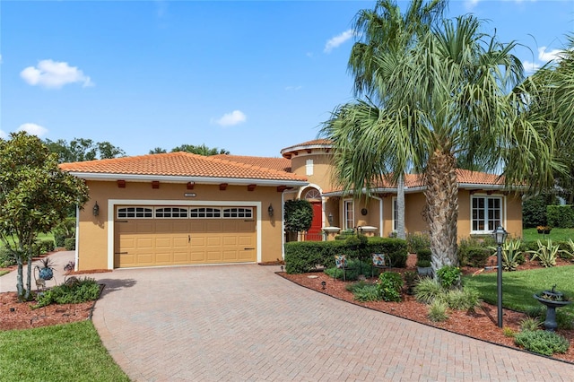 mediterranean / spanish home with a garage and a front yard