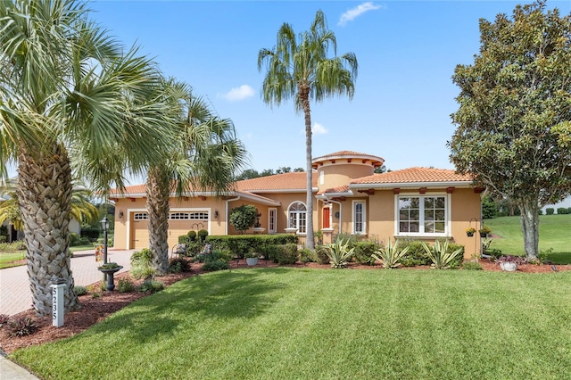 mediterranean / spanish house with a front yard and a garage