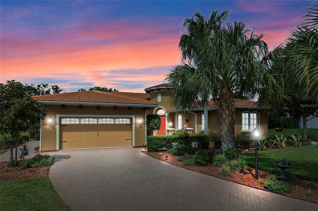 mediterranean / spanish house with a lawn and a garage