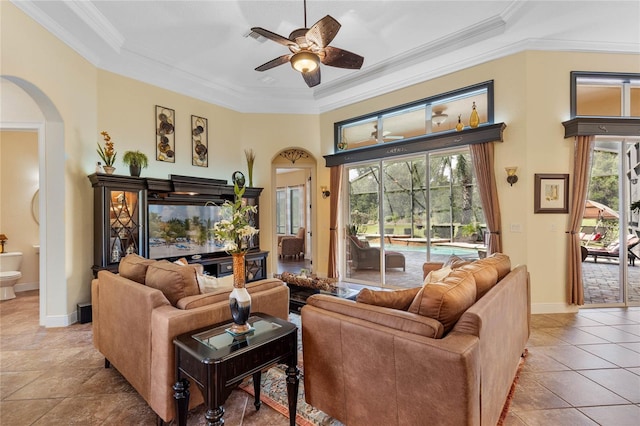 tiled living room with a healthy amount of sunlight, crown molding, and ceiling fan