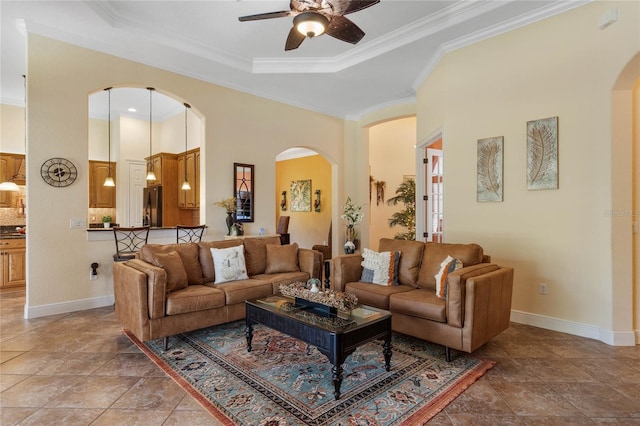 tiled living room with ceiling fan and crown molding