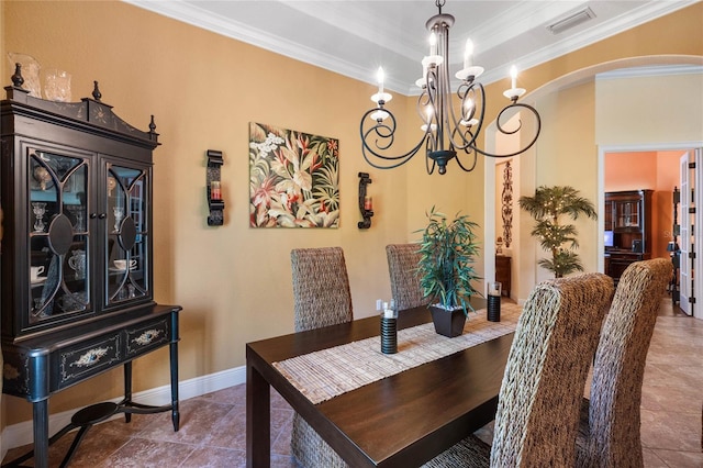 dining area featuring a tray ceiling, crown molding, and a chandelier