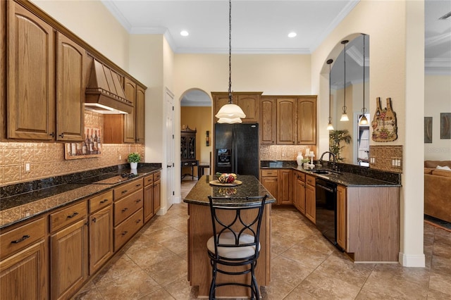 kitchen featuring black appliances, crown molding, a center island, decorative light fixtures, and sink