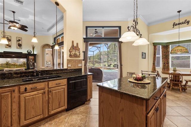 kitchen with dark stone counters, pendant lighting, dishwasher, a kitchen island, and ceiling fan