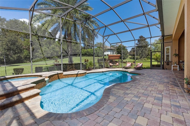 view of swimming pool with glass enclosure, an in ground hot tub, a lawn, and a patio