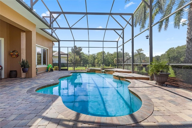 view of swimming pool featuring glass enclosure, a patio area, and a hot tub