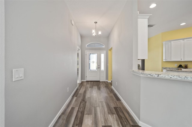 entryway with a chandelier and dark wood-type flooring