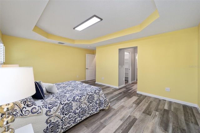 bedroom featuring hardwood / wood-style floors and a tray ceiling