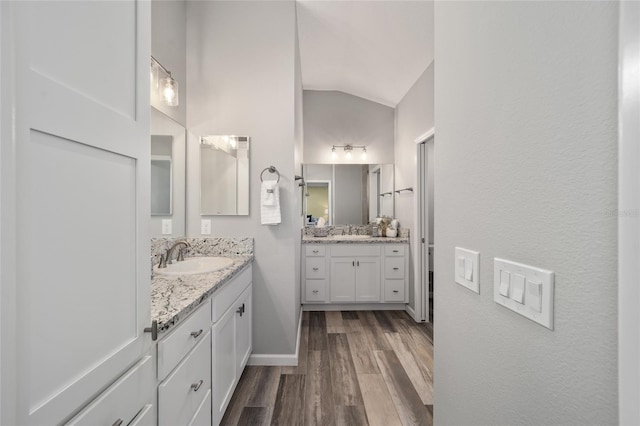 bathroom featuring vanity, hardwood / wood-style flooring, and lofted ceiling