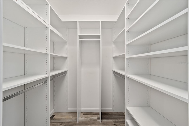 walk in closet with dark hardwood / wood-style flooring